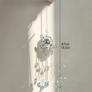 Detailaufnahme des Evil-Eye Hamsa Sonnenfängers mit funkelnden Kristallprismen und Metallkette.