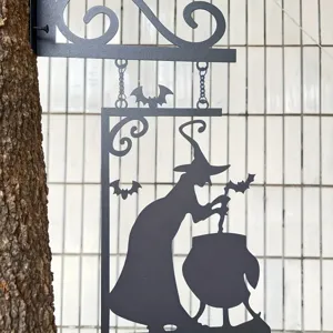 Λεπτομέρεια κρεμαστής μεταλλικής διακόσμησης τοίχου με σιλουέτα μάγισσας αποκριάς.