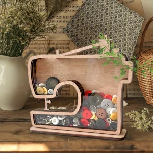 Caja de exposición de madera con forma de máquina de coser, botones y decoración retro.