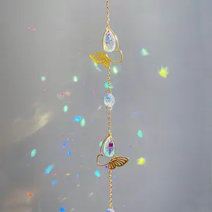 Close-up detail of hanging crystal suncatcher with butterfly accent and rainbow light reflections.