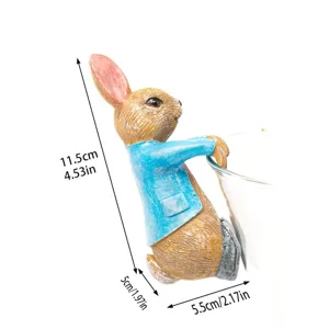 Vue détaillée de la jolie figurine suspendue de lapin en résine avec une veste bleue au jardin.