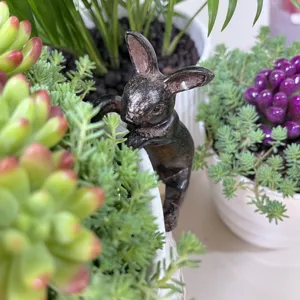 Gros plan d'une jolie figurine de lapin en résine pour décoration de pot de jardin.