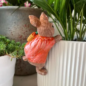 Gros plan de la figurine de lapin en résine suspendue, jolie déco pour pot de jardin.