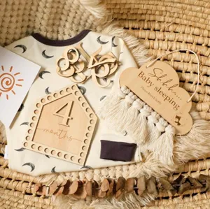 Detailed shot of a nordic wooden baby sleeping hanging sign styled in a warm woven basket.