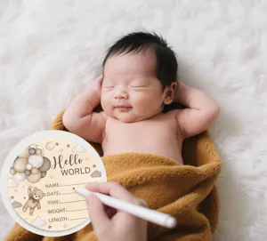 Newborn baby milestone wooden plaque detail shot showing engraved Hello World text.
