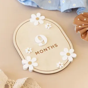 Wooden baby milestone card with cute daisies and number nine months for newborn photography props.