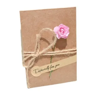 Tarjeta de felicitación vintage de papel kraft con cuerda y flor artificial rosa regalo.