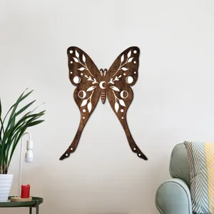 Wooden moth wall decor detail showing moon and leaf carved patterns in a cozy living room setup.