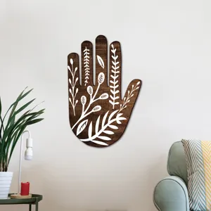 Bohemian wooden hand wall decor with white botanical leaf pattern, cozy living room scene detail.