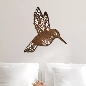 Wooden hummingbird wall decor detail showing boho carved patterns above a cozy white bed.