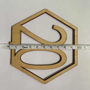 Vue détaillée d'un numéro de table hexagonale en bois avec ruban à mesurer pour dimensions.