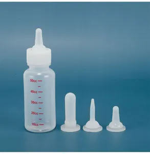 Detail shot showing a transparent plastic pet feeding bottle with clear red capacity cc volume scale.