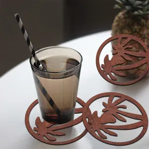 Bruine ronde houten onderzetter met creatief palmboom ajour ontwerp voor tafel.