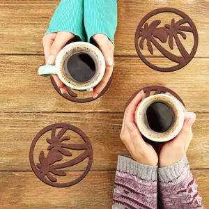 Detail van houten koffiekopjes onderzetter met uitgesneden palmboomontwerp op houten tafel.