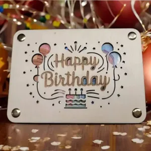 Detalle de la tarjeta de regalo de cumpleaños de madera con texto grabado y motivos festivos.