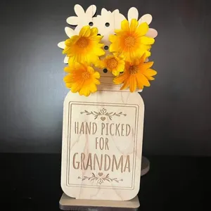 Detail de vase bocal en bois avec fleurs jaunes et inscription gravee pour deco.