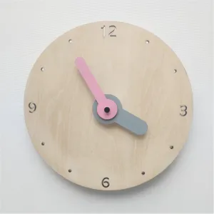 Détail d'horloge murale silencieuse en bois nordique, design minimaliste mains roses.