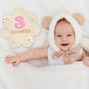 Hölzerne Baby Meilenstein Karte Blumen Requisite mit lächelndem Kind für Fotografie.