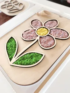 Bandeja sensorial de madera con forma de flor y arroz de colores para manualidades DIY.