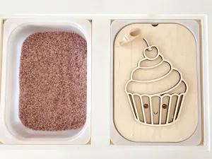 Detalle del juguete sensorial de madera con tablero de cupcake, cuchara y bandeja.
