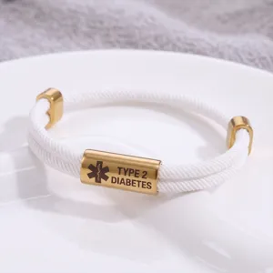 Vista dettagliata del bracciale medico intrecciato bianco con tubo inciso in oro.