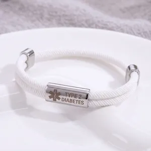 Dettaglio bracciale medico in acciaio inox, corda intrecciata bianca con incisione.