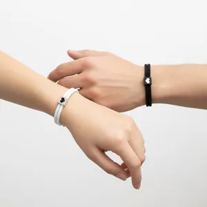 Primer plano detallado de pulseras de cordón milanés para parejas con lindos dijes de corazón.