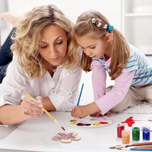 Wooden flower blank cutouts detail scene with DIY painting tools for children crafting art.