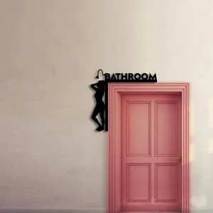 Close-up of black silhouette door corner decoration with bathroom text and woman figure.