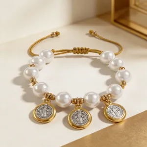 Vue détaillée des perles de médaille saint Benoît sur le bracelet doré réglable et élégant.
