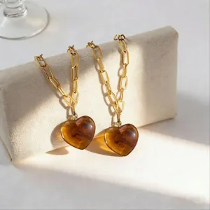 Nahaufnahme Detail von bernsteinfarbenem Harz Herz Anhänger mit goldener Kette, Schmuck.