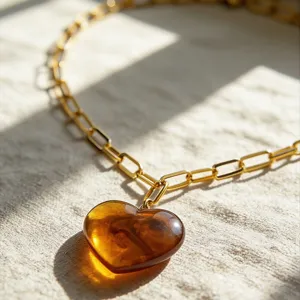 Detailaufnahme einer stilvollen goldenen Kette mit einem wunderschönen Harz-Herz-Anhänger.