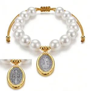 Vue detaillee du magnifique bracelet de perles avec medaille Saint-Benoit dore clair.