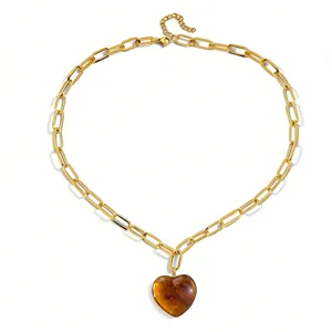 Goldene Büroklammer Kette mit transparentem bernsteinfarbenen Harz Herz Anhänger für Damen.