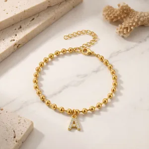Bracciale di perline dorate con ciondolo a lettera A luminoso e scintillante con strass.