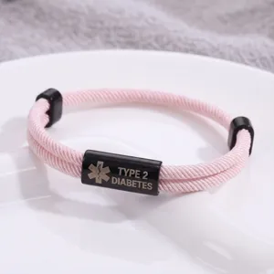 Primo piano dettagliato del braccialetto medico intrecciato rosa con tubo in acciaio inossidabile.