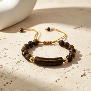 Nahaufnahme Detailaufnahme des Natur-Tigerauge-Edelstein-Perlenarmbands mit goldenem Brückenanhänger.