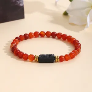 Elegant red gemstone beaded bracelet with black center stone and gold accents for women.