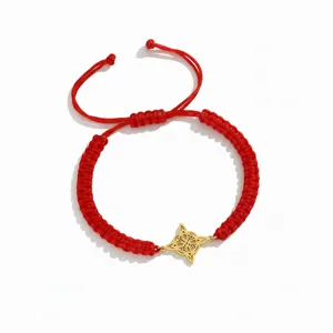 Rood gevlochten koordarmband met gouden roestvrijstalen heksenknoop hanger detailopname.