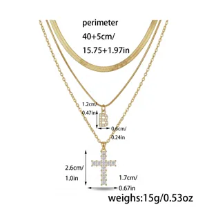Collier multicouche en acier inoxydable dore avec pendentifs lettre et croix scintillants.