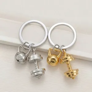 Detail shot of gold and silver fitness keychains featuring cute miniature kettlebells and dumbbells.