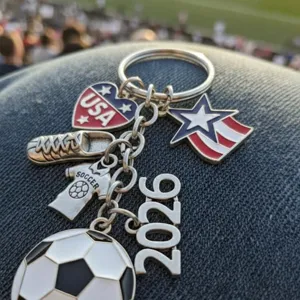 Metal soccer keychain with USA flag heart, cleat, and 2026 charms for sports fans.
