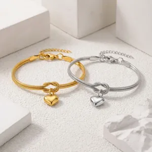 Detailopname van roestvrijstalen hartknoop slangketting armbanden in goud en zilver.