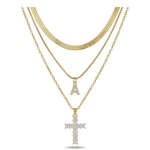 Collier multicouche doré avec pendentif lettre A en zircon et croix pour femme.