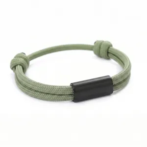 Detailed view of the green woven paracord bracelet featuring a sleek black stainless steel tube.