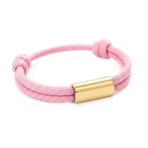 Closeup of pink paracord bracelet with gold stainless steel tube detail and adjustable design.