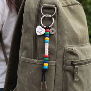Close up shot of a colorful beaded keychain featuring 2026 charms and a heart pendant in daily use.