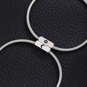Close-up detail of stainless steel couple bracelet featuring unique sun and moon magnetic charms.