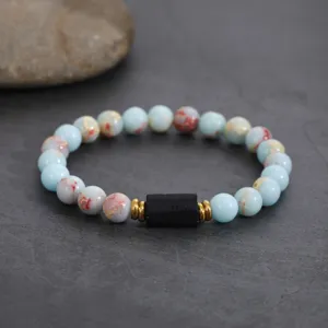 Detailed close-up shot of beaded bracelet featuring natural stone beads and black center accent.