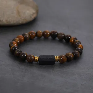 Close-up of a natural tiger eye and black stone beaded bracelet with metallic spacers.